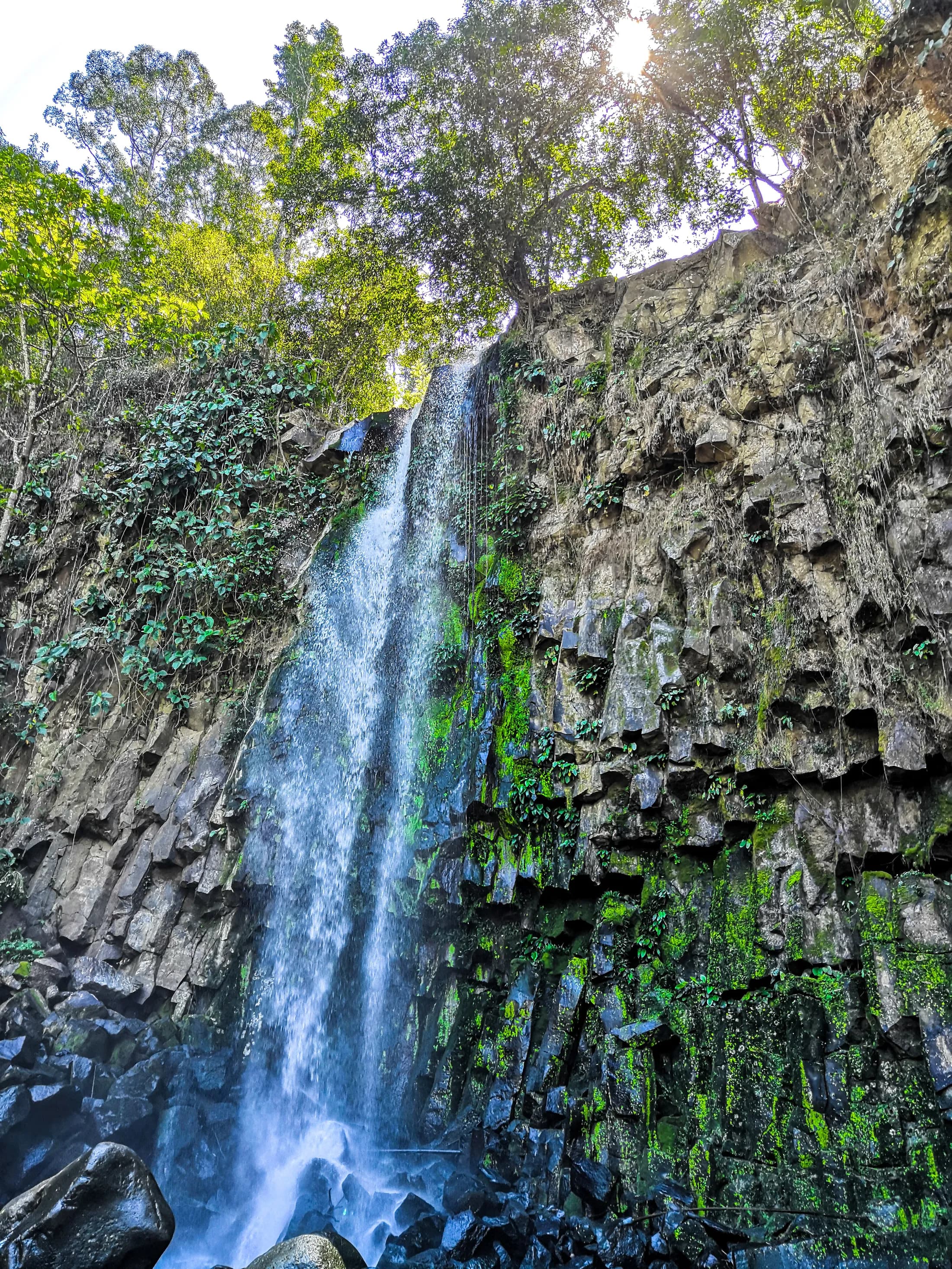 Dila Falls flowing through forested rock at CEDAR in Impasugong